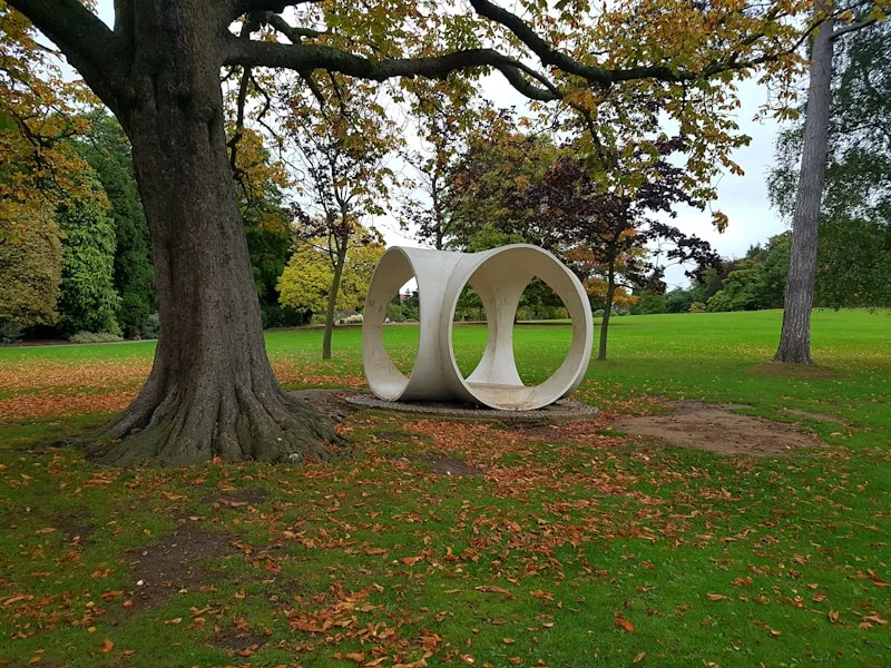 Battalion Park hillside with carved battalion numerals visible on the escarpment, mature trees framing the slope