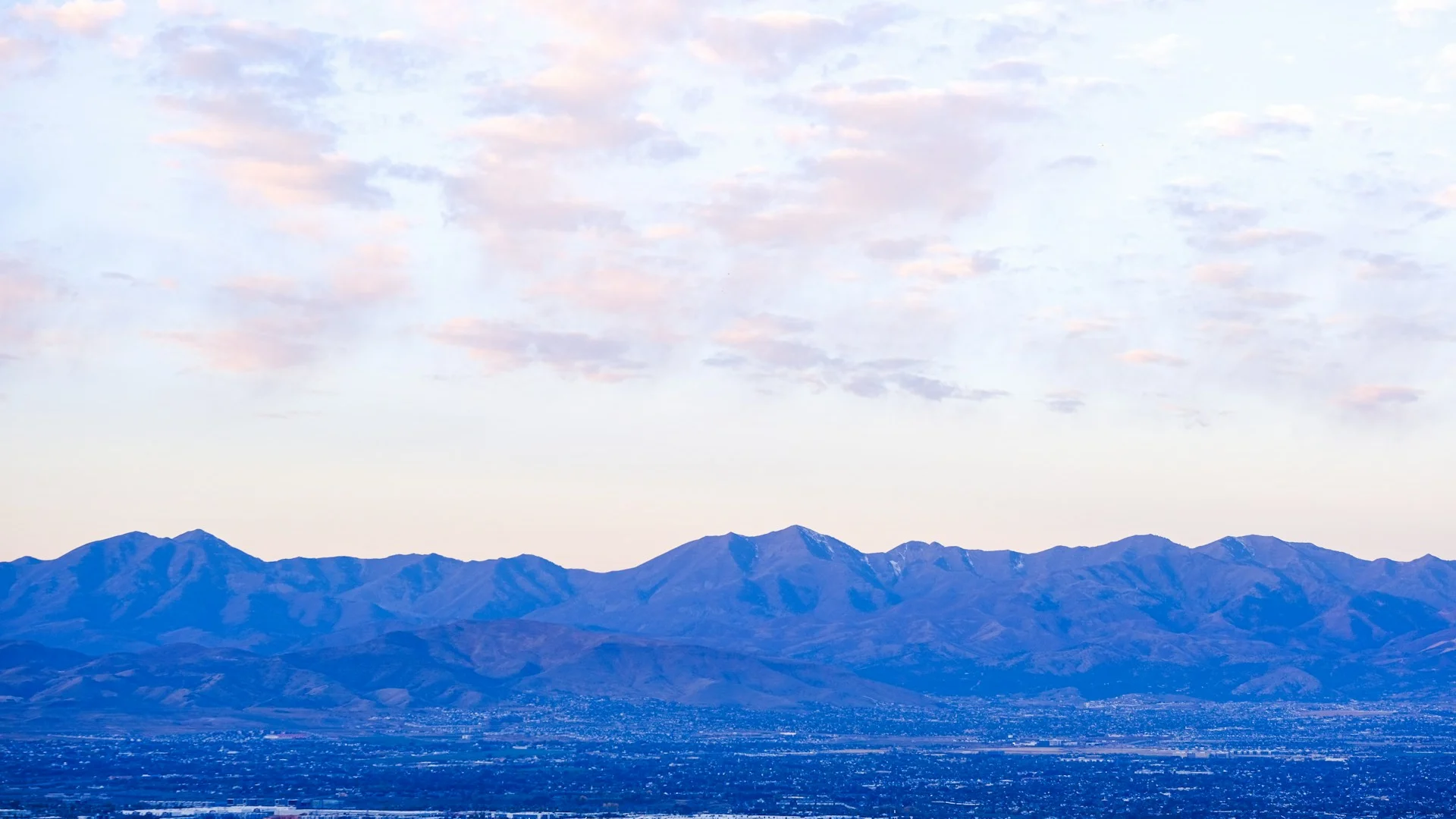 Signal Hill ridge at dusk with Calgary city lights and Rocky Mountains on the horizon